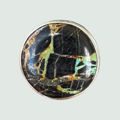 Black Jack turquoise ring in sterling silver, close-up of the round cabochon cut into panels by heavy black matrix