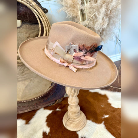 Camel felt rancher hat with a wide flat brim, pale pink band, feather cluster and silver thunderbird