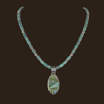 Green Turquoise Inlay Pendant Necklace in Navajo Sterling Silver, by Rick Tolino, shown on an espresso background