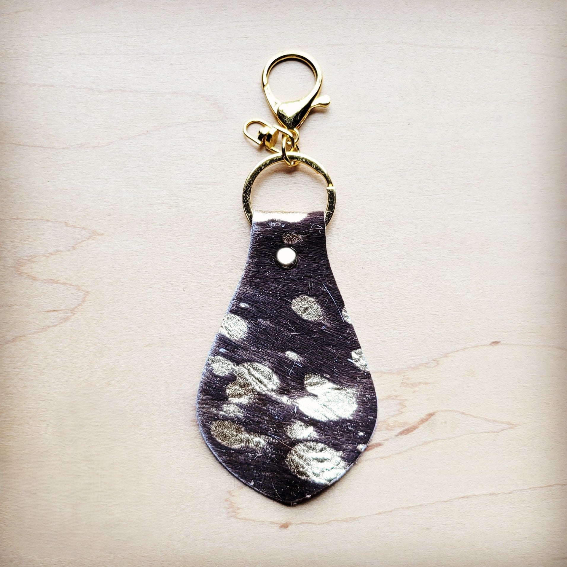 Brown hair-on-hide leather key chain with silver metallic spotting and gold hardware