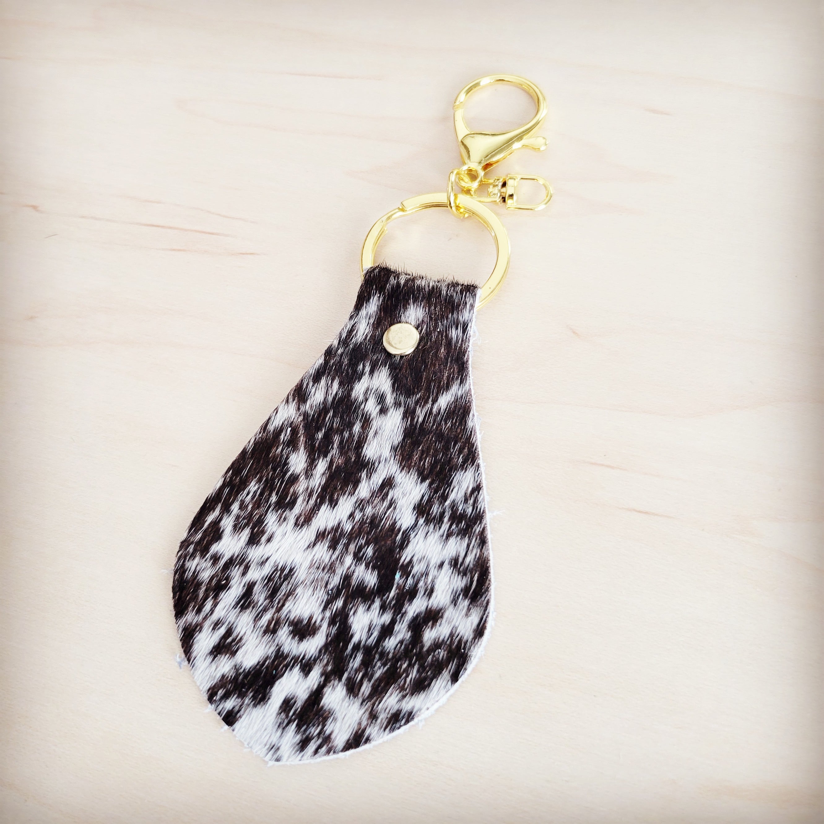 Brindle cowhide leather key chain shown clipped to a bag
