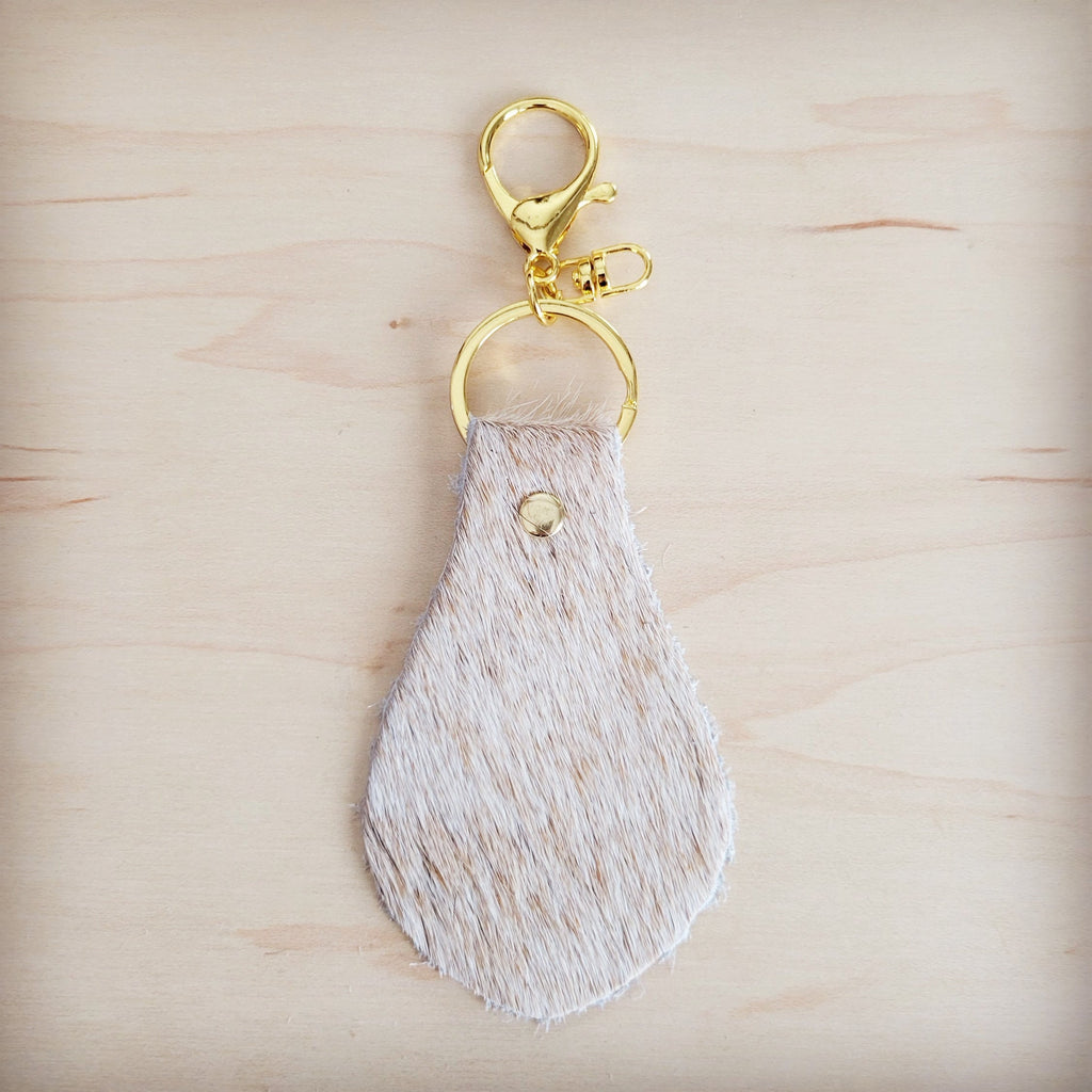 Two light tan hair-on-hide leather key chains showing natural shade variation