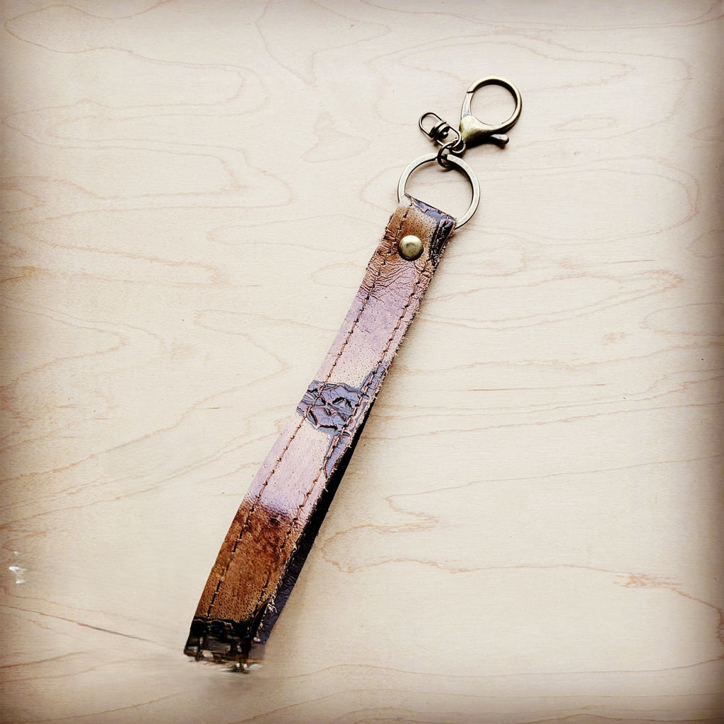 Close view of the steer and scroll emboss on the tan leather wristlet key chain