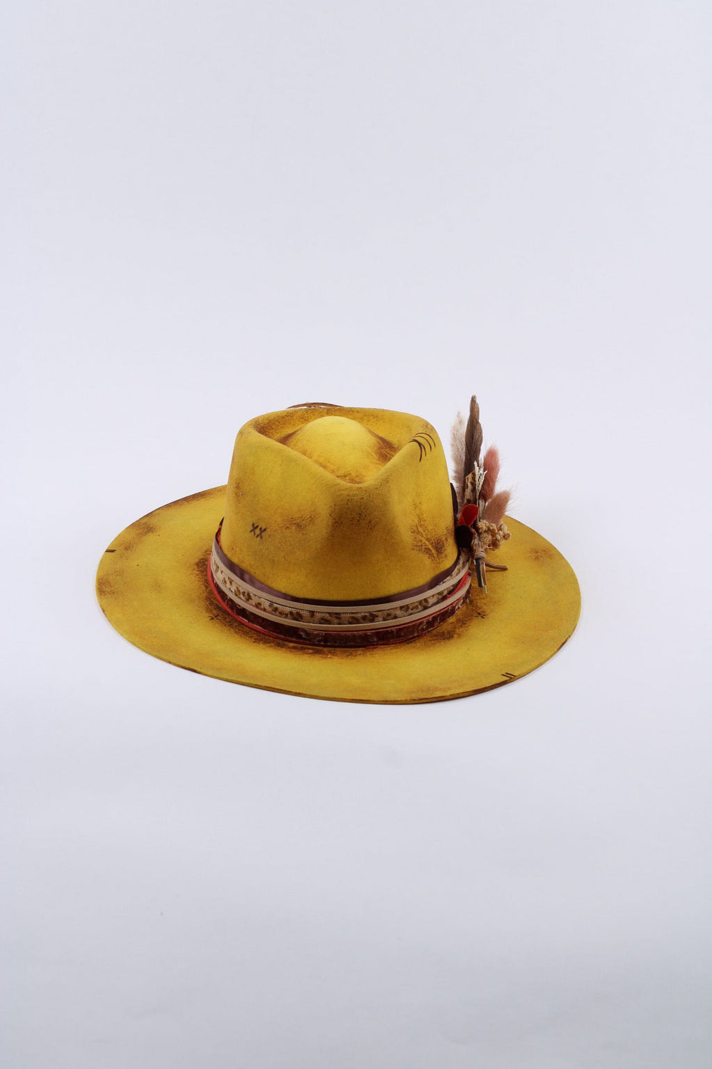 Close view of the hand burning on the yellow wool rancher hat
