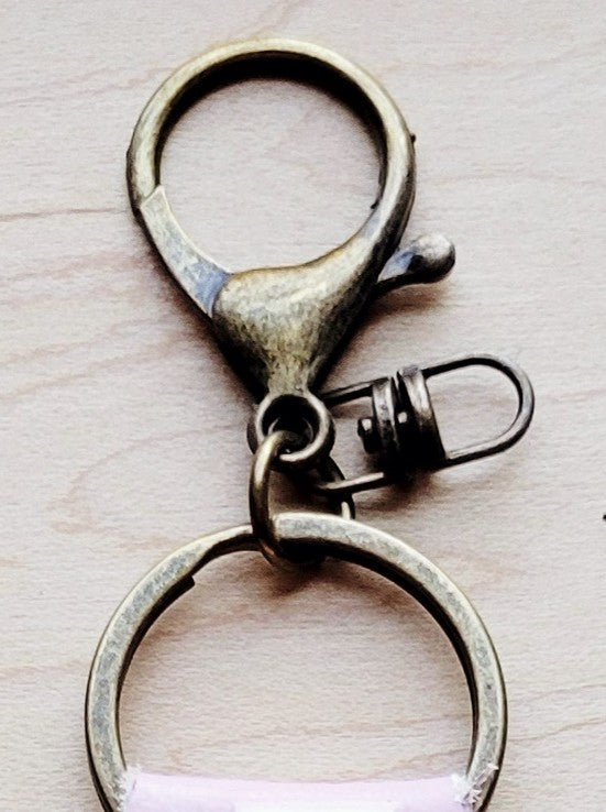 Light tan hair-on-hide leather key chain shown beside other western key fobs