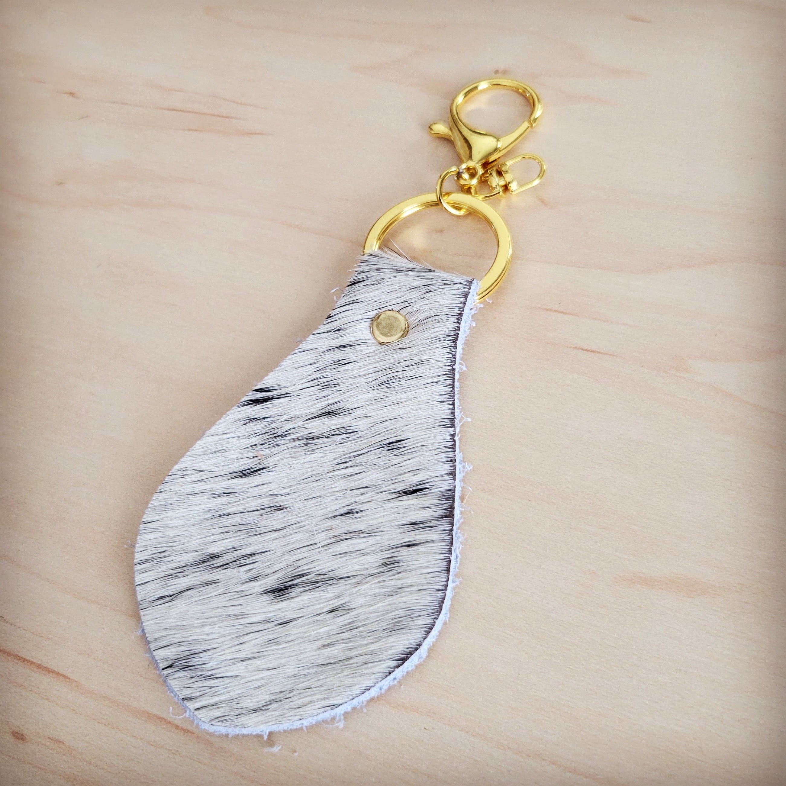Brown and white brindle cowhide key chain shown at an angle
