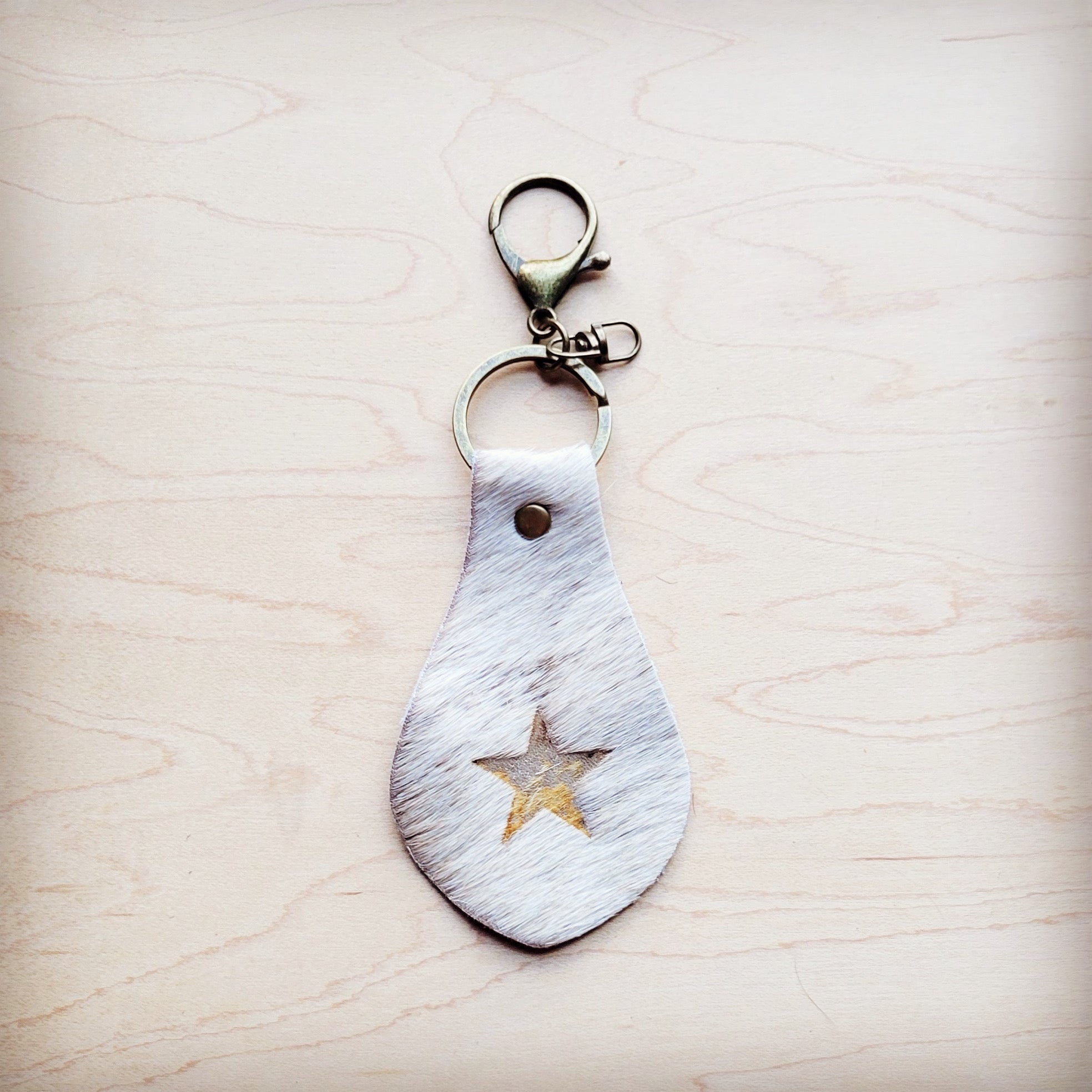 White hair-on-hide leather key chain with a branded star and swivel clip