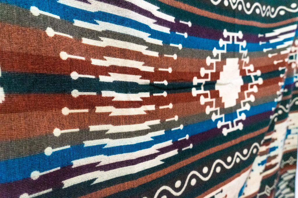 Close-up of the cream diamond medallion with blue, rust and plum stripes on the Evergreen alpaca blend blanket