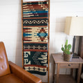 Forest green, rust and cream Andean alpaca blend blanket hanging on a wooden ladder beside a leather chair