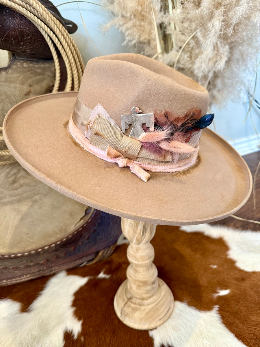 Camel felt rancher hat with a wide flat brim, pale pink band, feather cluster and silver thunderbird