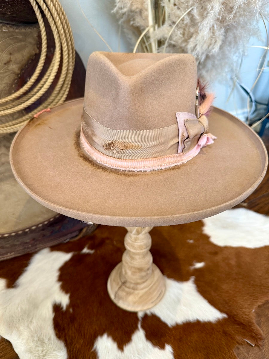 Front view of the camel felt rancher hat showing the teardrop pinch crown and scorched pink band
