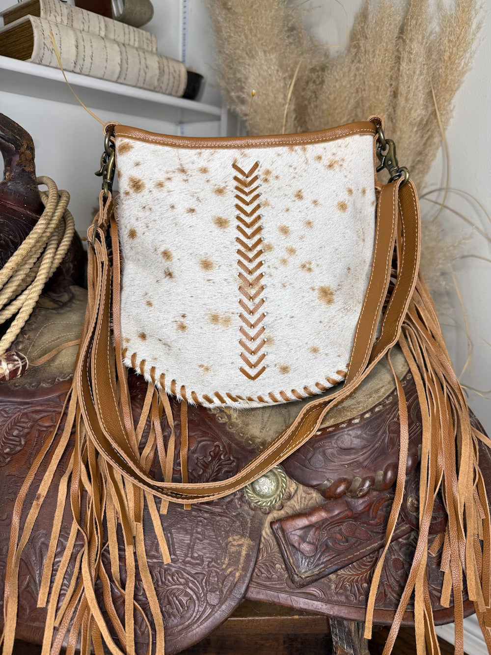 Western shoulder bag in white and cinnamon speckled hair-on cowhide with tan leather chevron lacing and long side fringe