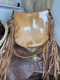 Western shoulder bag in caramel and white hair-on cowhide with tan leather chevron lacing and long leather fringe
