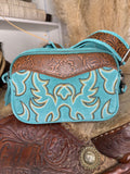 Turquoise suede western crossbody bag with cream and gold boot stitch embroidery and a carved tooled leather rosette