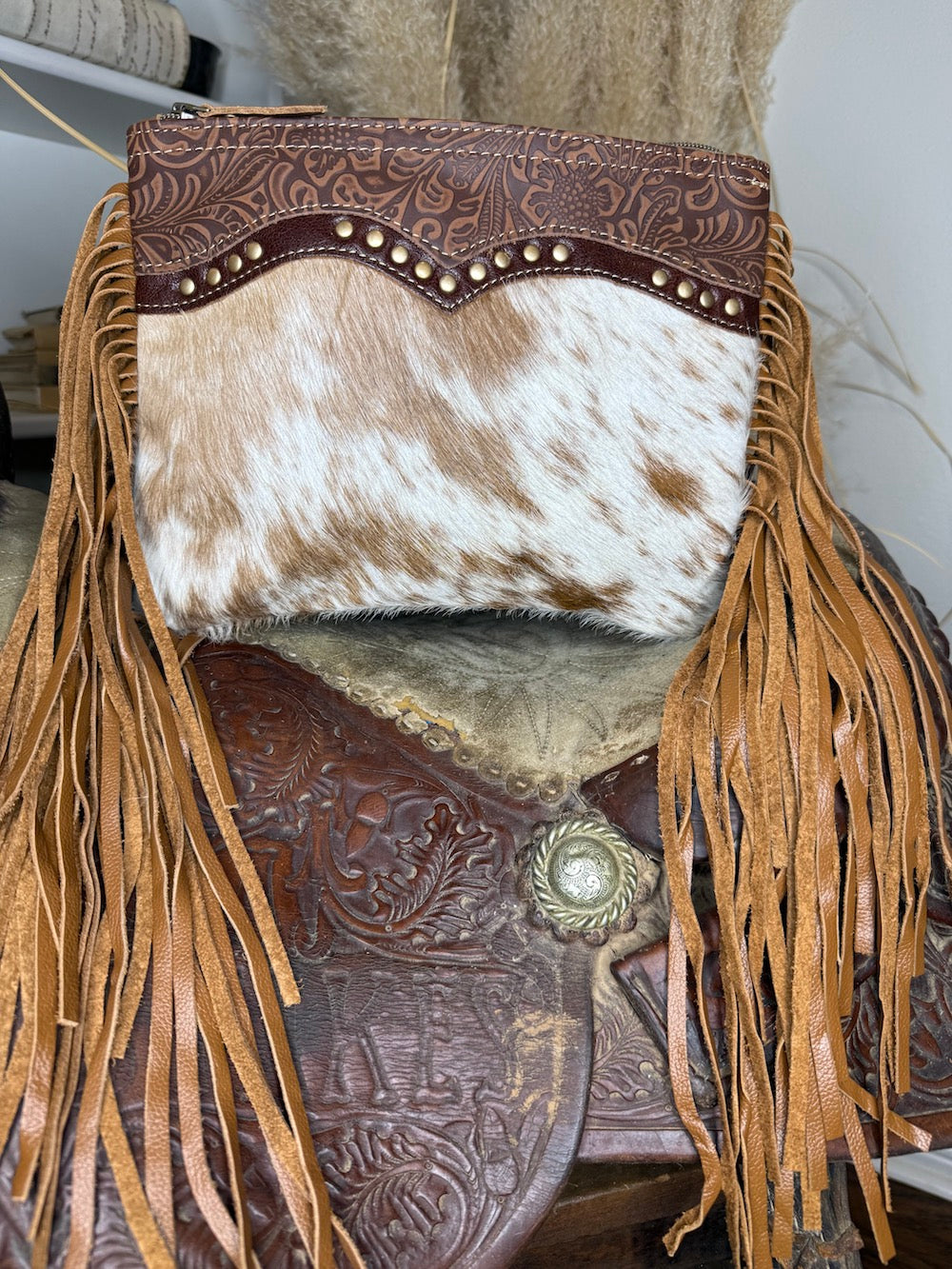 Speckled cowhide western bag with a scalloped studded tooled leather yoke and long tan leather fringe