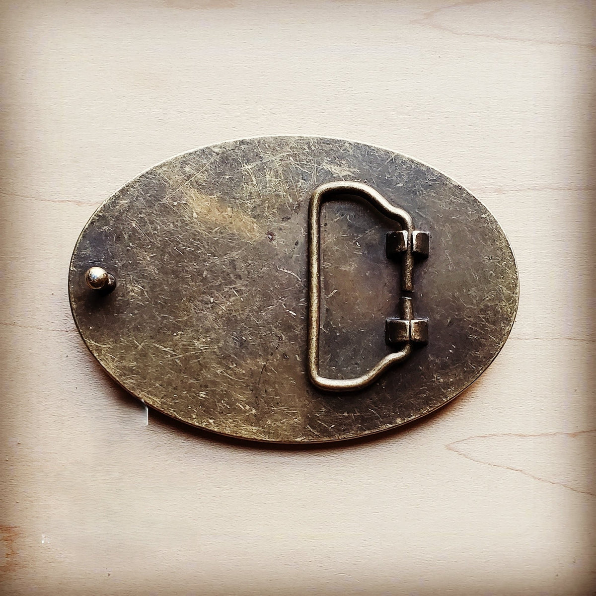 Rope edge belt buckle in white spotted hair on hide, third view