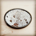 Oval belt buckle faced in white spotted hair on hide with an antique gold rope edge