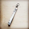 White embossed leather wristlet key chain with a swivel clip
