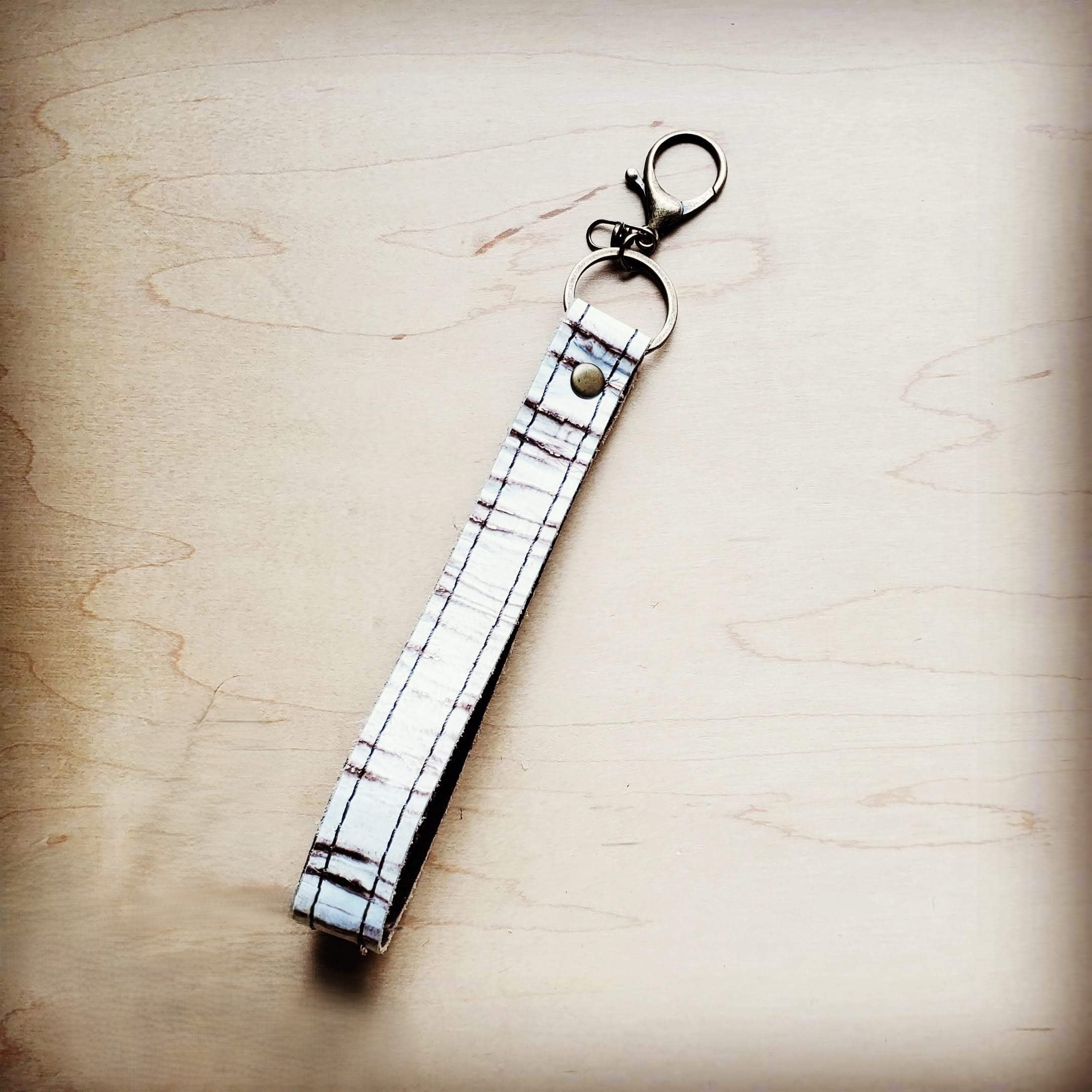 White embossed leather wristlet key chain with a swivel clip