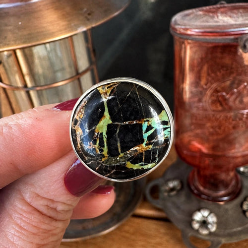 Black Jack turquoise sterling silver ring held in hand, showing the scale of the large 17.5 carat round stone