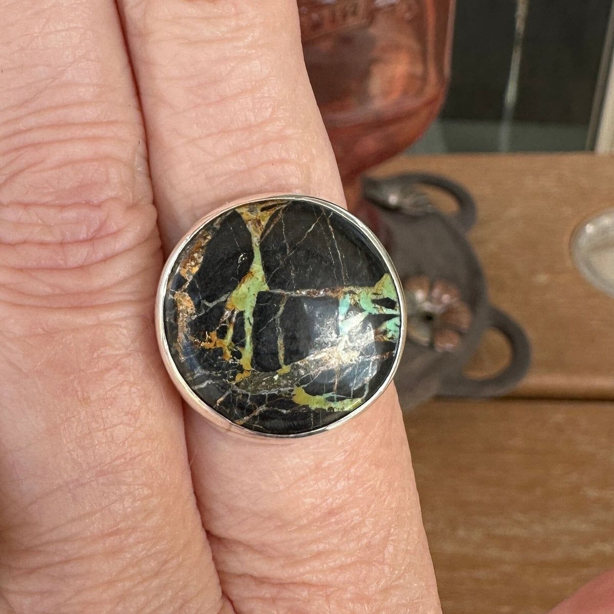 Black Jack turquoise ring in sterling silver worn on a finger, size 8 1/4