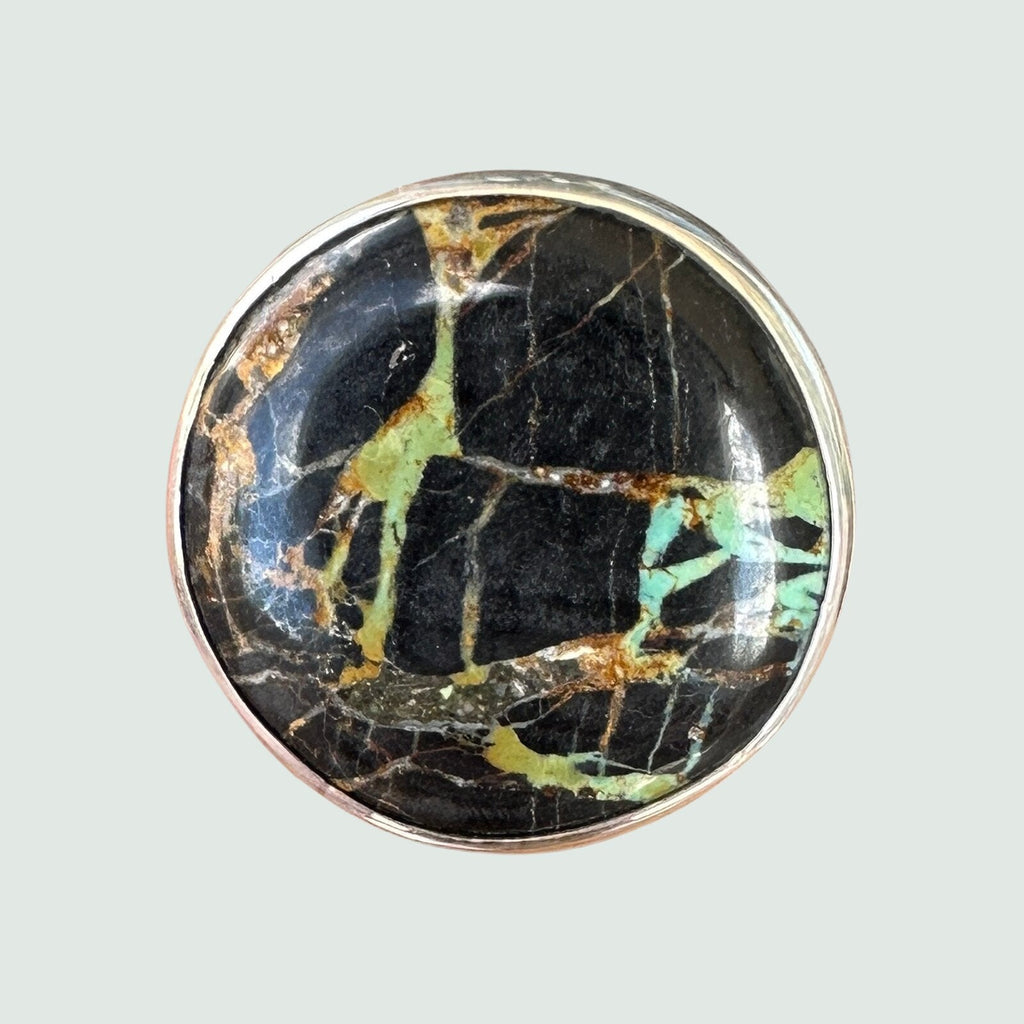 Black Jack turquoise ring in sterling silver, close-up of the round cabochon cut into panels by heavy black matrix