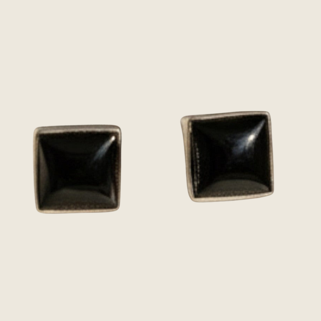 Black onyx square stud earrings in sterling silver, shown on a bone linen background
