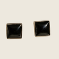 Black onyx square stud earrings in sterling silver, shown on a bone linen background