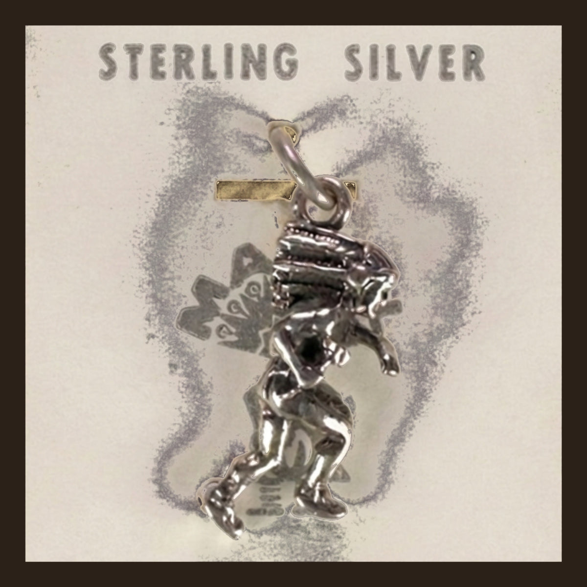Dancer in Headdress Charm in Sterling Silver, Vintage Maisel's New Old Stock, shown on an espresso background