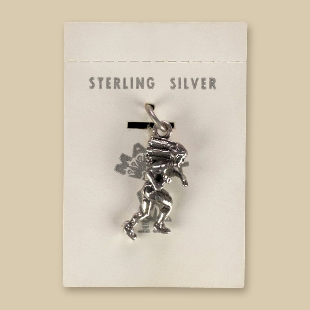 Dancer in Headdress Charm in Sterling Silver, Vintage Maisel's New Old Stock, shown on a sand background