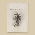 Dancer in Headdress Charm in Sterling Silver, Vintage Maisel's New Old Stock, shown on a sand background