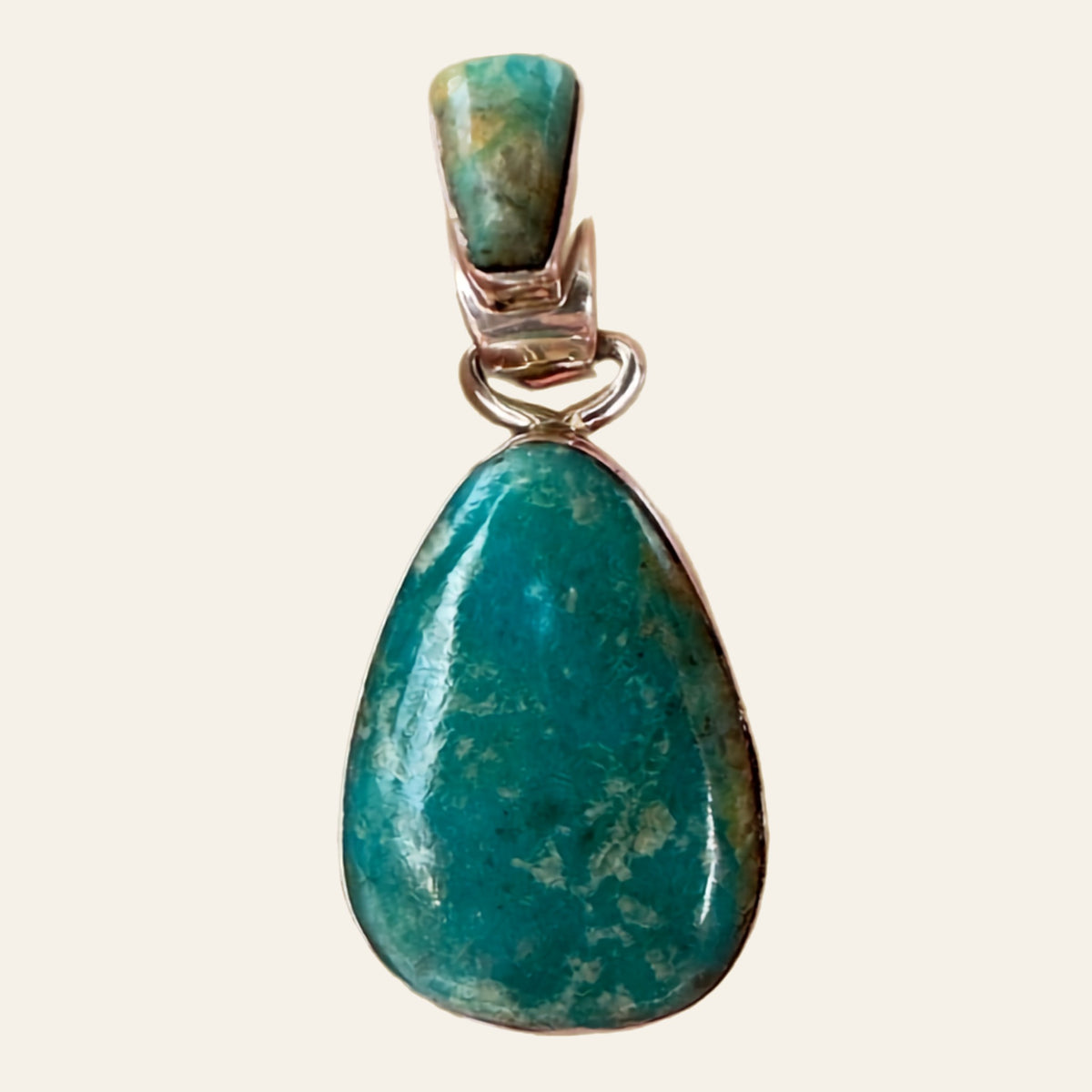 Fox Turquoise Teardrop Pendant in Sterling Silver, by Martinez, shown on a cream background
