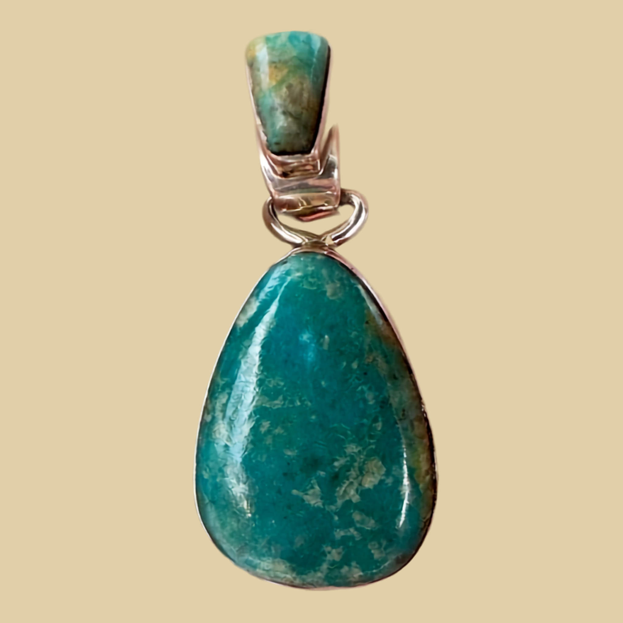 Fox Turquoise Teardrop Pendant in Sterling Silver, by Martinez, shown on a desert plaster background