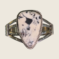 White buffalo cuff bracelet in Navajo sterling silver by P. Yazzie, shown on a bone linen background