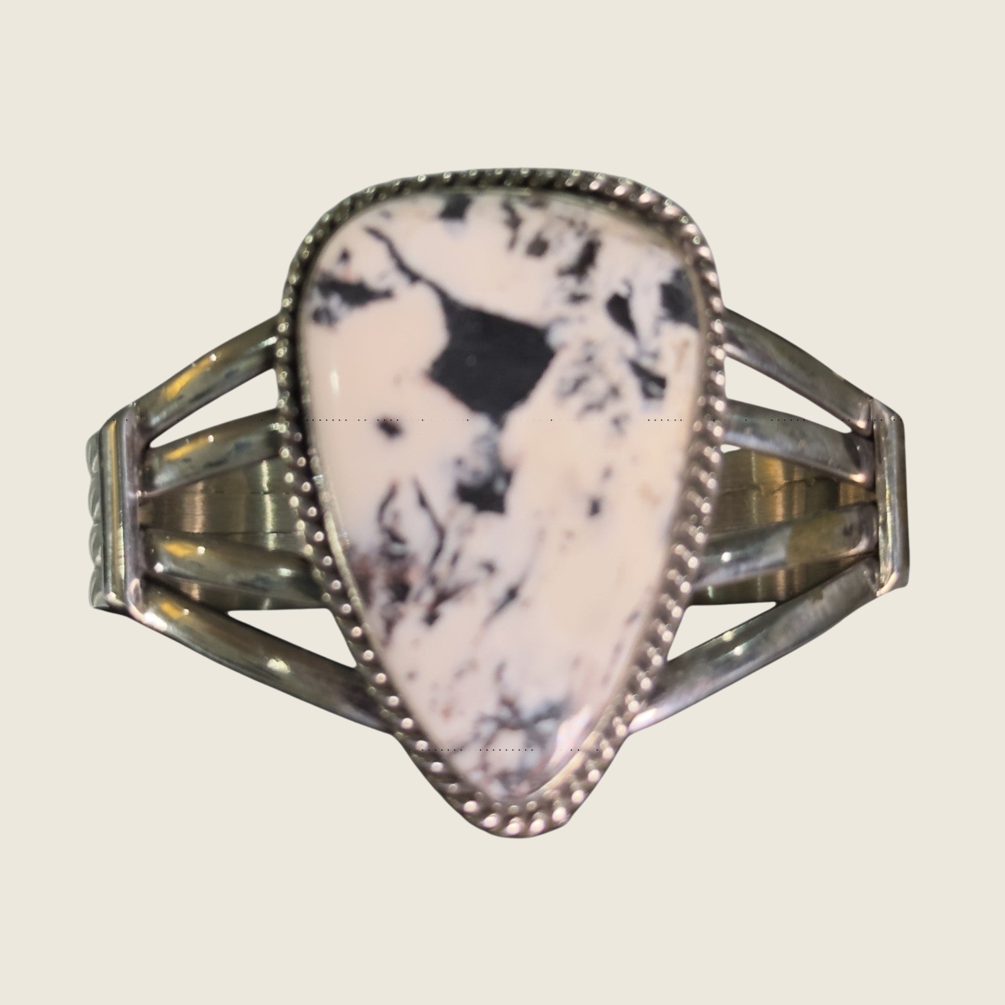 White buffalo cuff bracelet in Navajo sterling silver by P. Yazzie, shown on a bone linen background