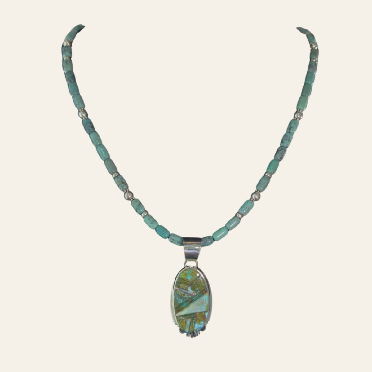 Green Turquoise Inlay Pendant Necklace in Navajo Sterling Silver, by Rick Tolino, shown on a cream background