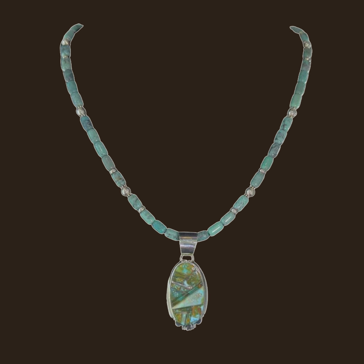 Green Turquoise Inlay Pendant Necklace in Navajo Sterling Silver, by Rick Tolino, shown on an espresso background
