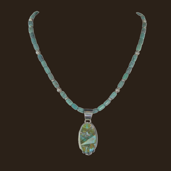 Green Turquoise Inlay Pendant Necklace in Navajo Sterling Silver, by Rick Tolino, shown on an espresso background