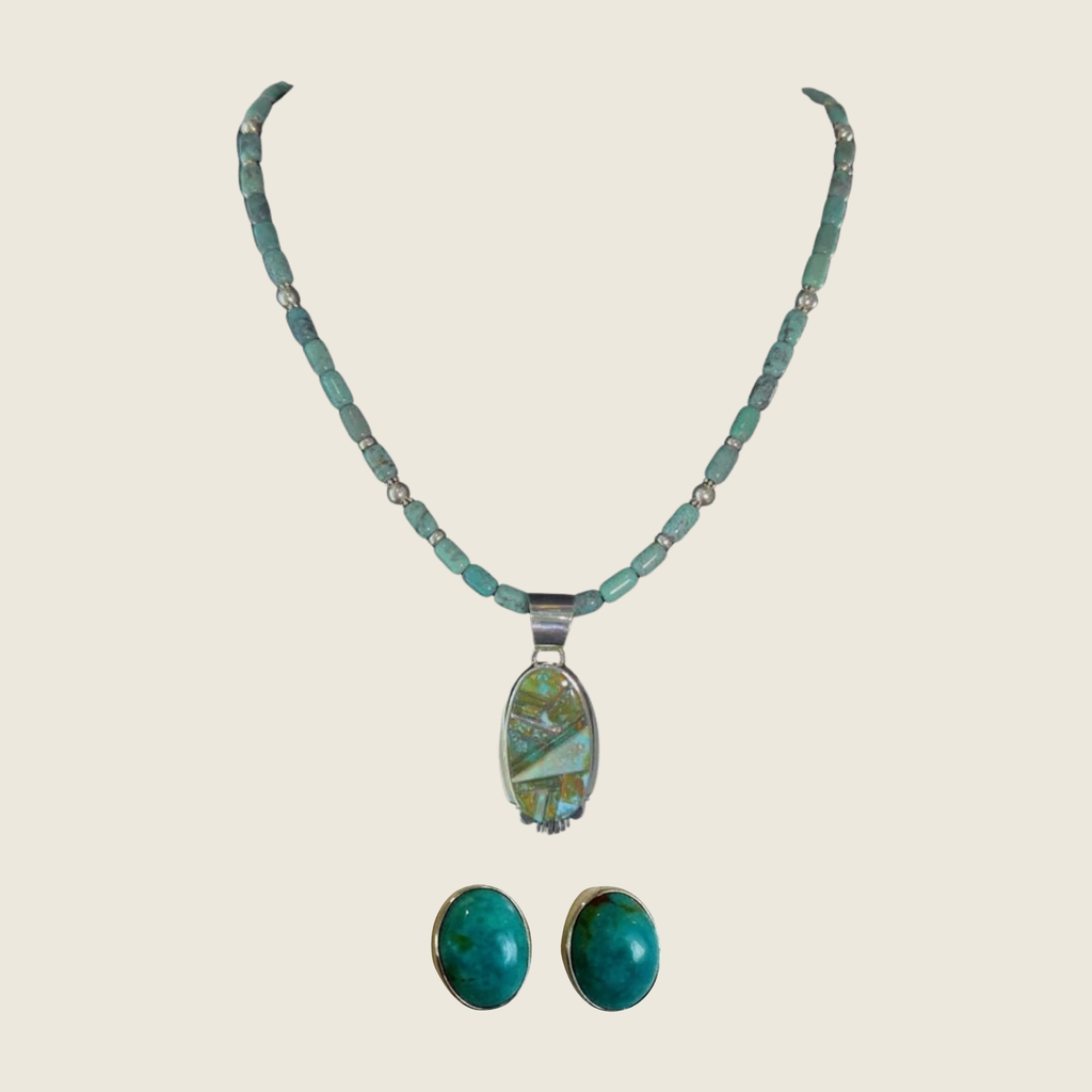 Green turquoise pendant and oval turquoise stud earrings jewelry set in sterling silver, shown on a bone linen background
