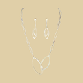 Leaf necklace and earrings jewelry set in sterling silver by Grace Chin, shown on a desert plaster background