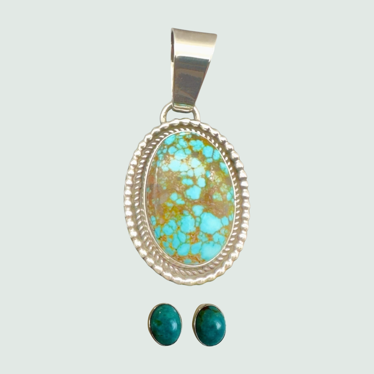 Kingman Red Web turquoise pendant and oval turquoise stud earrings jewelry set in sterling silver, shown on a sage mist background