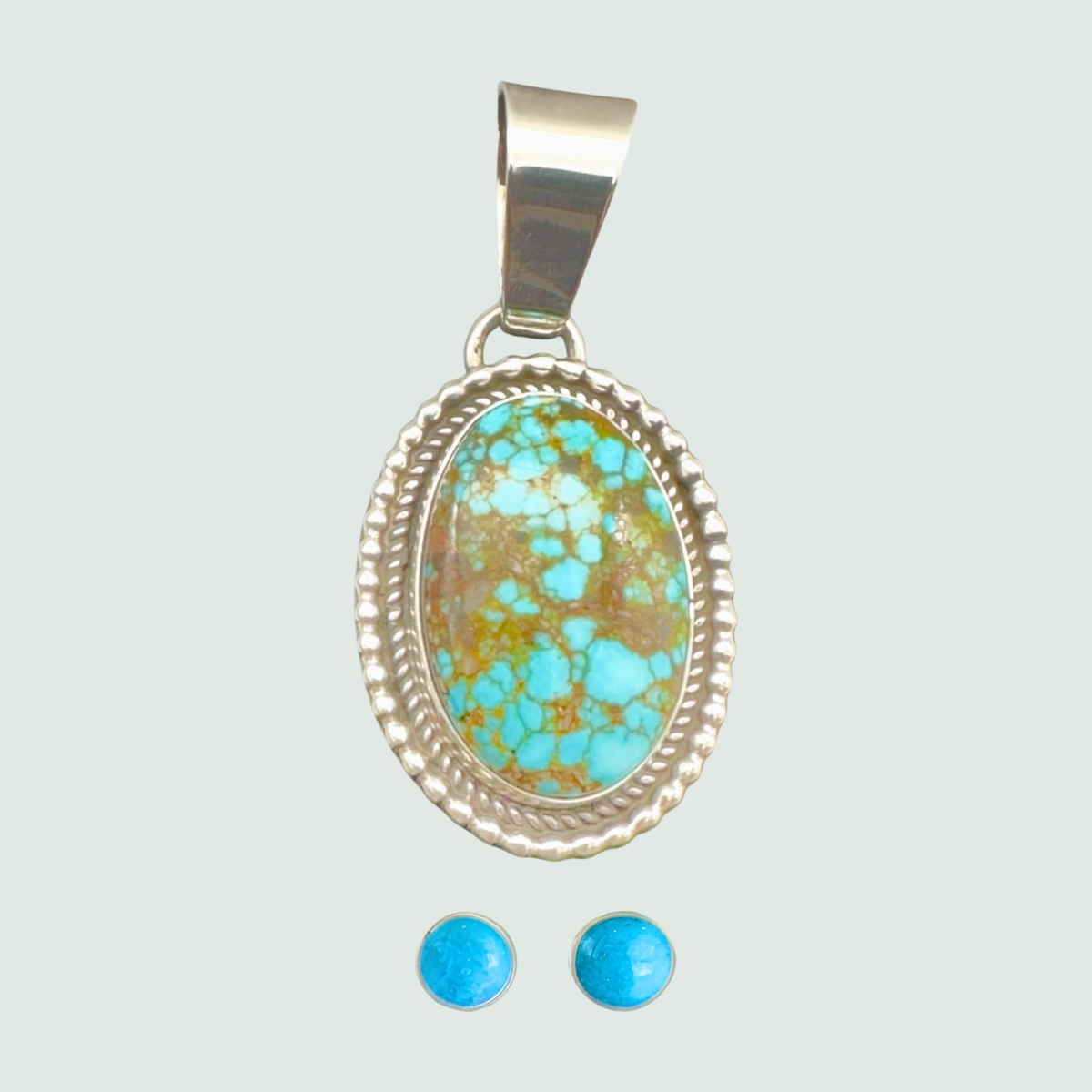 Kingman Red Web turquoise pendant and turquoise stud earrings jewelry set in sterling silver, shown on a sage mist background