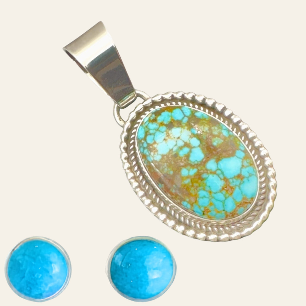 Kingman Red Web Turquoise Pendant and Stud Earrings Set in Sterling Silver, shown on a cream background