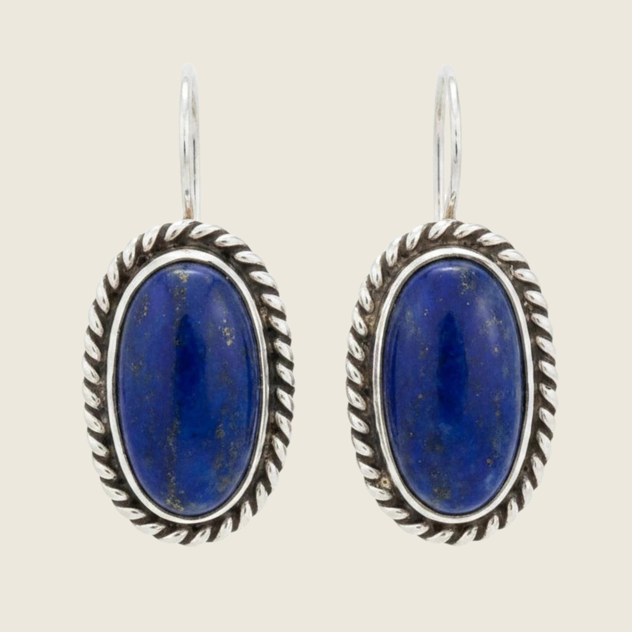 Lapis lazuli oval drop earrings in sterling silver, shown on a bone linen background