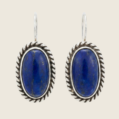 Lapis lazuli oval drop earrings in sterling silver, shown on a bone linen background