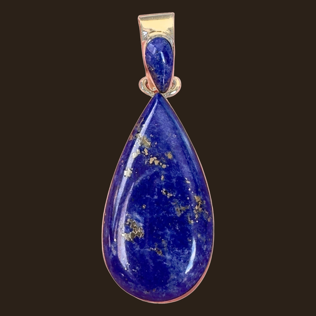 Lapis Lazuli Teardrop Pendant in Sterling Silver, by Martinez, shown on an espresso background