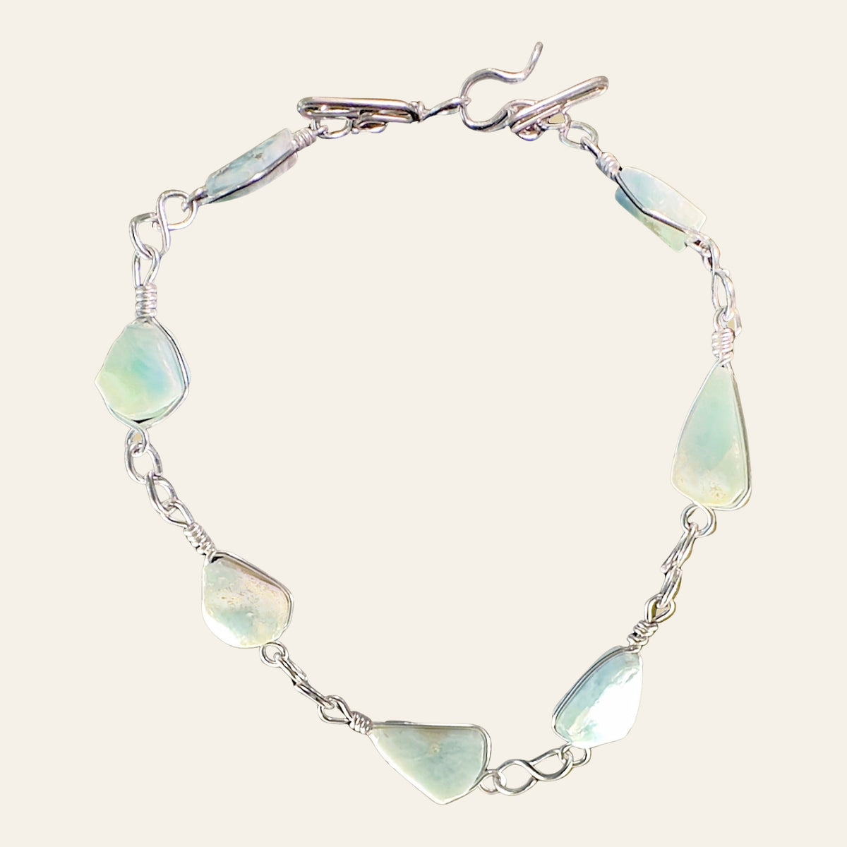 Larimar Adjustable Anklet and Bracelet in Sterling Silver, shown on a cream background