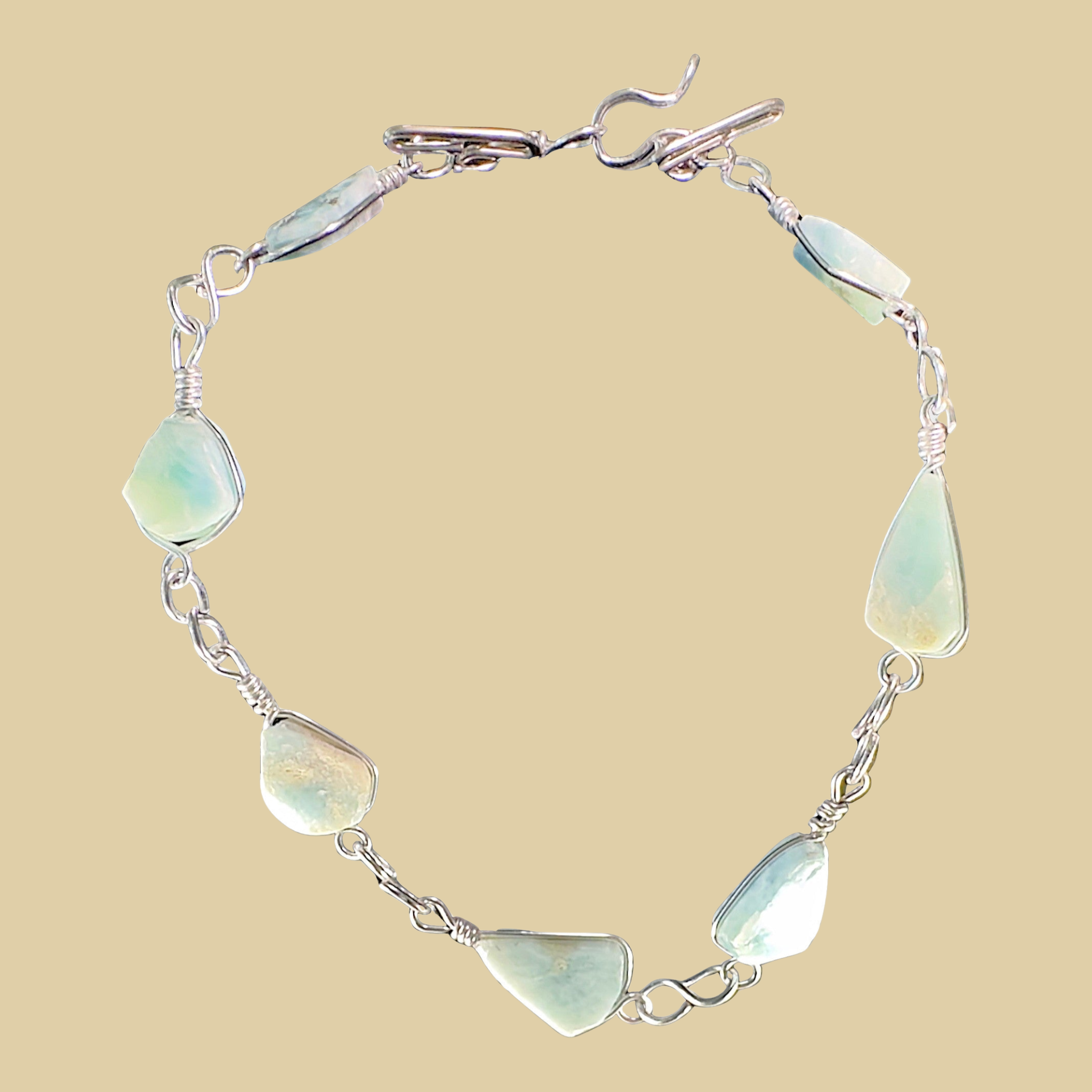 Larimar Adjustable Anklet and Bracelet in Sterling Silver, shown on a desert plaster background