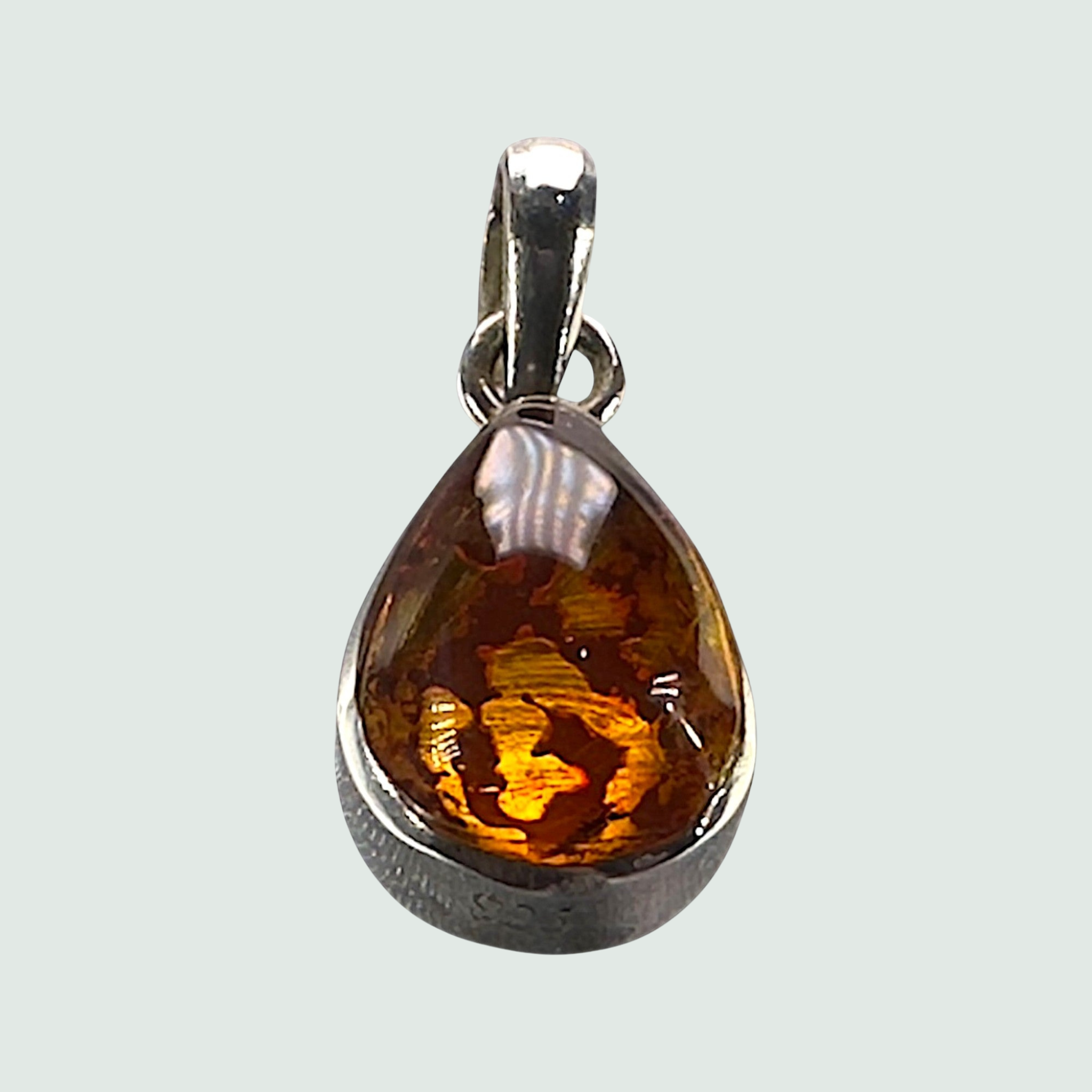 Larimar and Amber Reversible Teardrop Pendant in Sterling Silver, shown on a sage mist background
