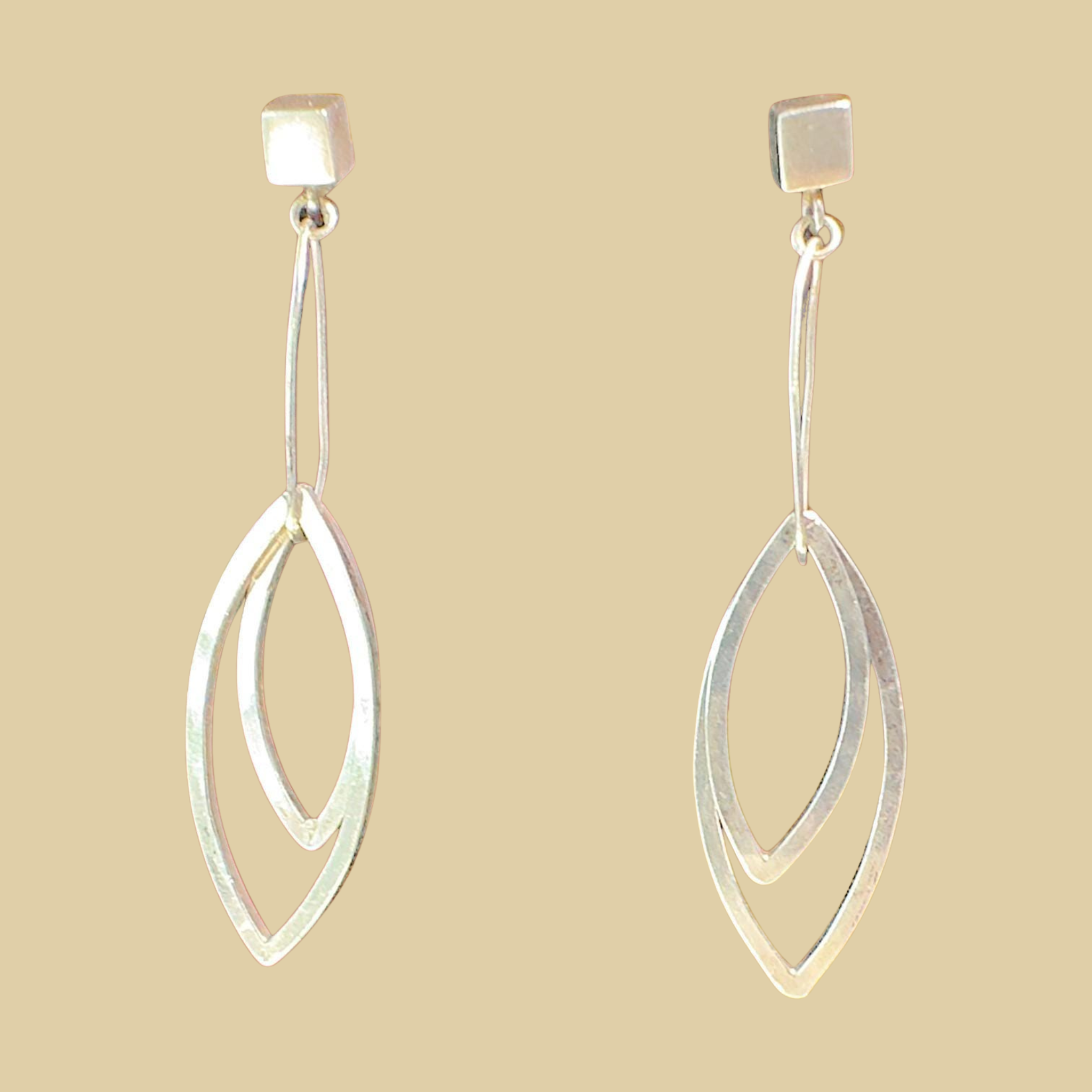 Leaf Dangle Earrings in Sterling Silver, by Grace Chin, shown on a desert plaster background